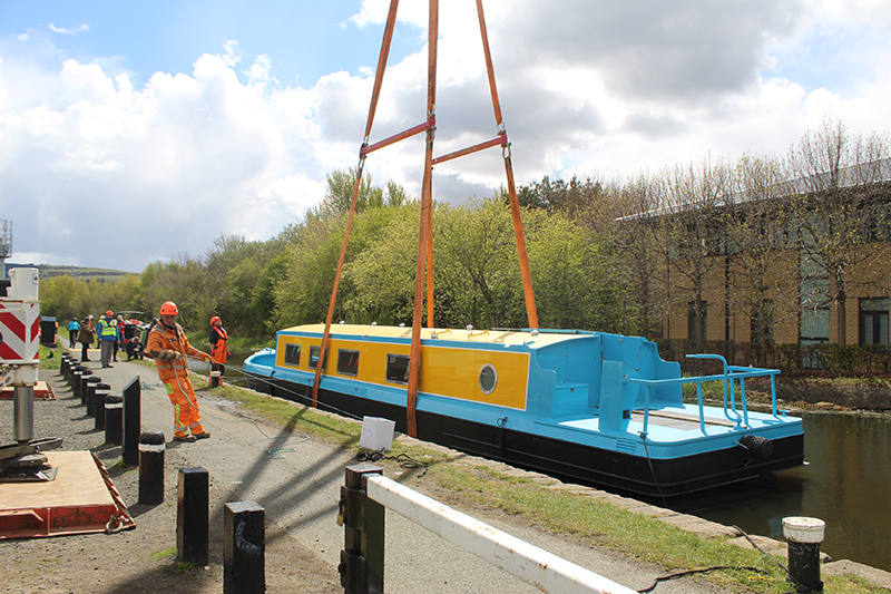 The All Aboard canal boat being craned into the Union Canal
