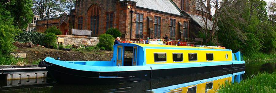 People Know How's All Aboard canal boat moored in front of Polwarth Parish Church