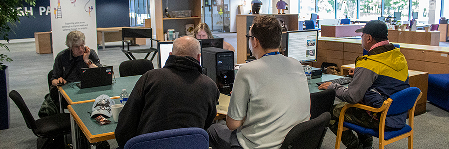 A Reconnect Digital & Wellbeing Coordinator supporting someone to use a desktop computer