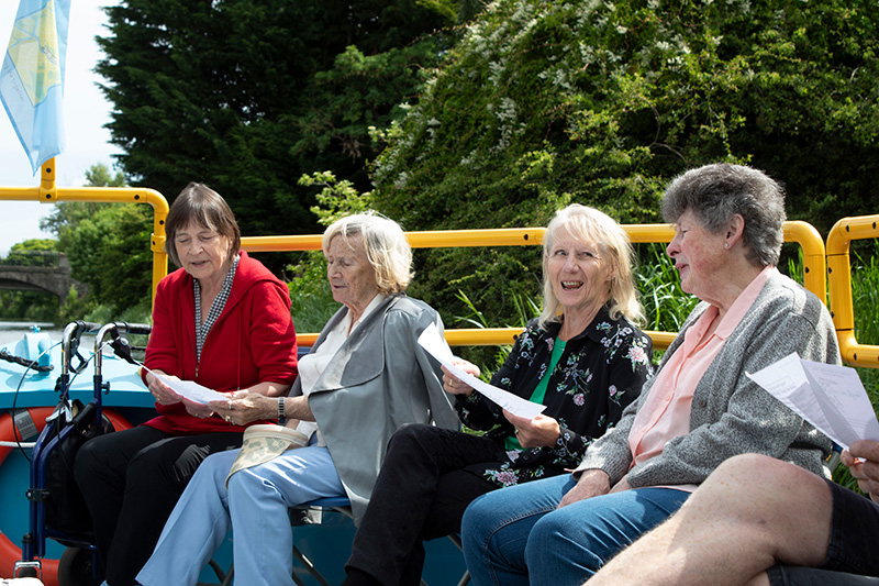 Four singers sitting beside one another on the All Aboard canal boat