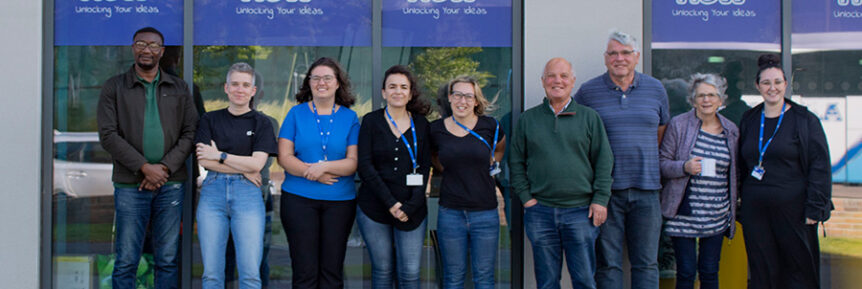 A row of volunteers standing outside People Know How's office