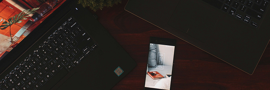 Two laptops and a smartphone on a table